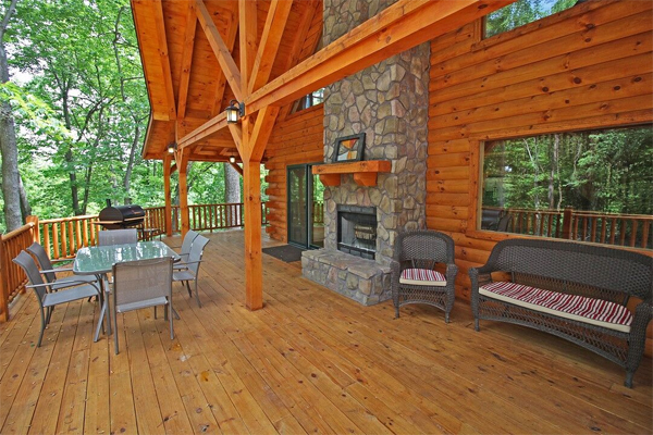 long wrap around porch, exposed beams, outdoor fireplace, dining area, patio sofa