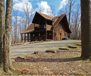 looking between 2 trees 2 two story lodge with open patio view