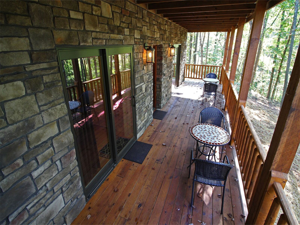 stone wall, sliding glass door, round table and chairs