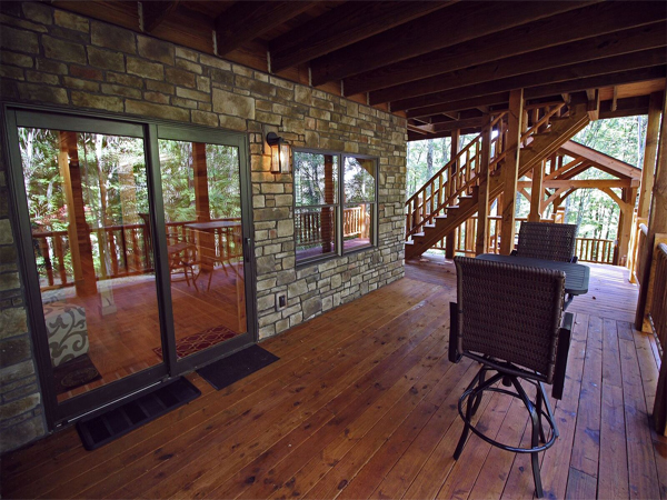 covered porch, patio doors, table and chairs, stone wall