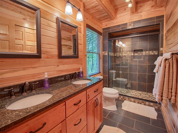 bathroom, tile flooring, glass shower door, double sink vanity