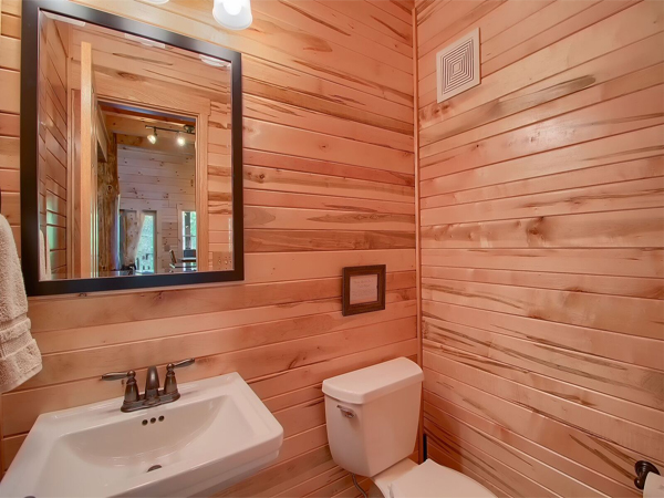 wooden bathroom, white sink, wall mounted mirror, white toilet