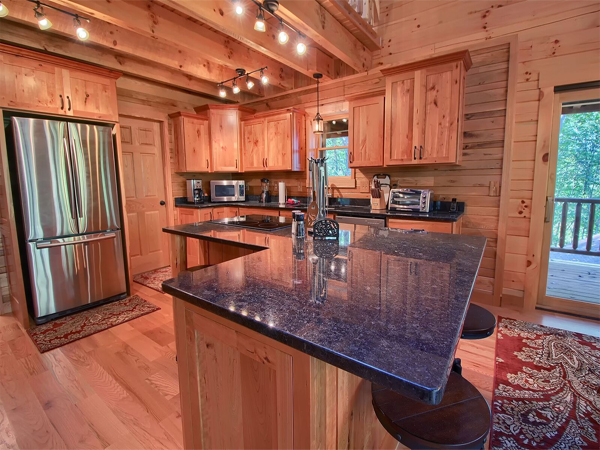 kitchen area, wooden cabinets, granite countertop, stainless steel refrigerator 