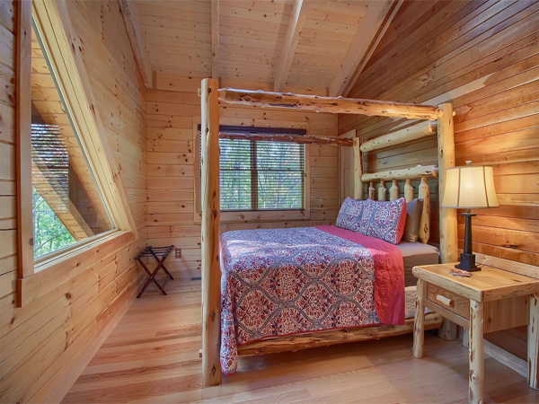 bedroom with triangular window, large wooden bed