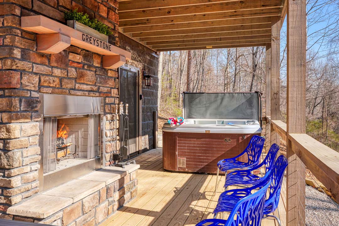 hot tube, chairs and stone fireplace on deck