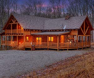 two story log cabin, large wrap around deck, twilight photo
